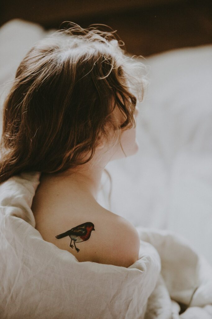 Woman with a semi-permanent bird tattoo on her shoulder